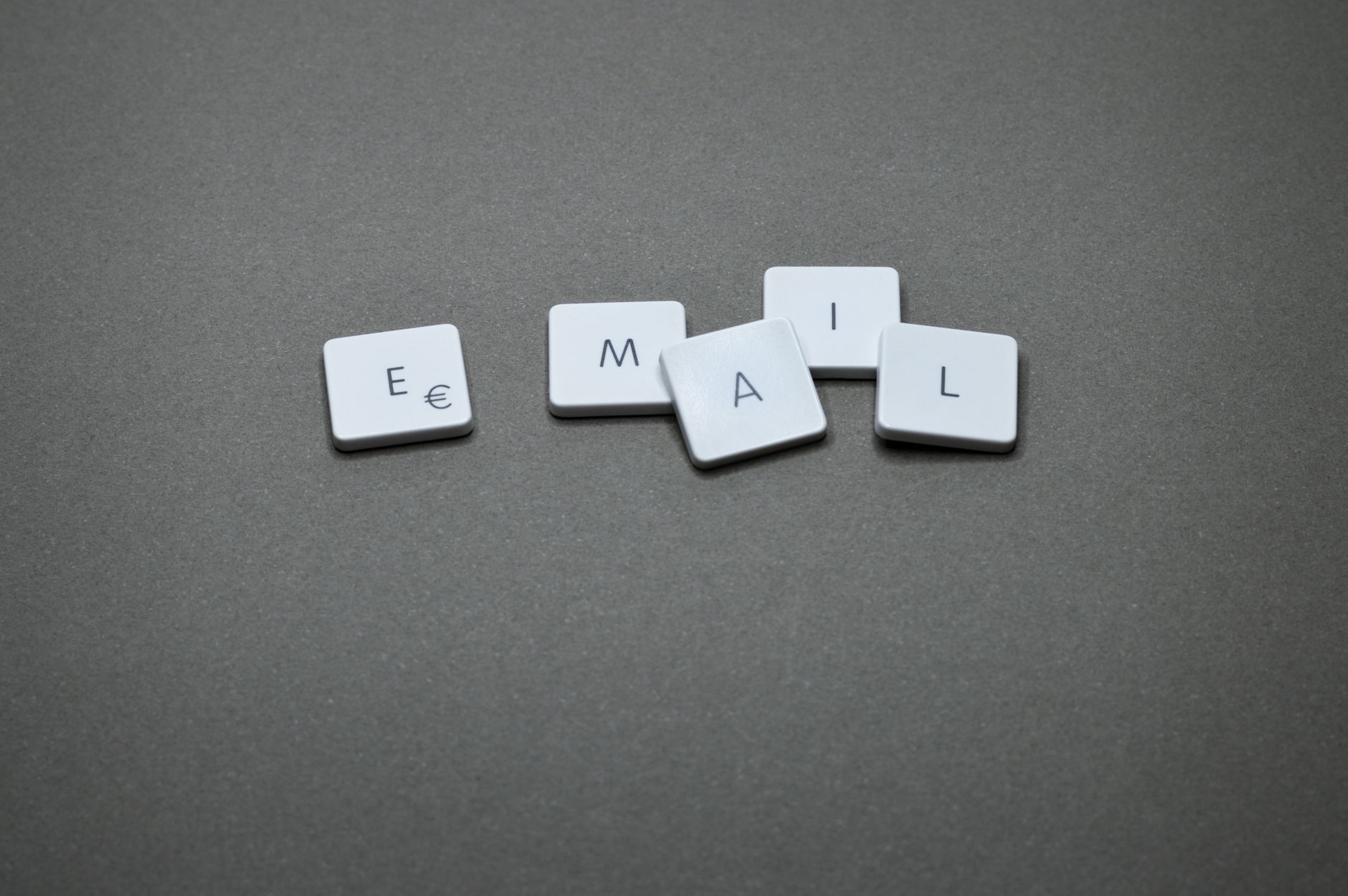 Keyboard tiles arranged to spell the word email on a gray background