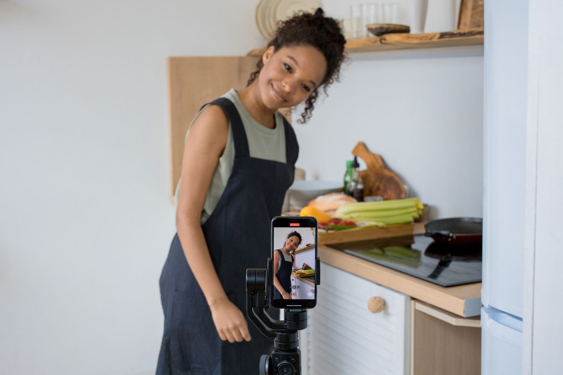 Créatrice de contenu filmant une vidéo culinaire avec un smartphone sur stabilisateur