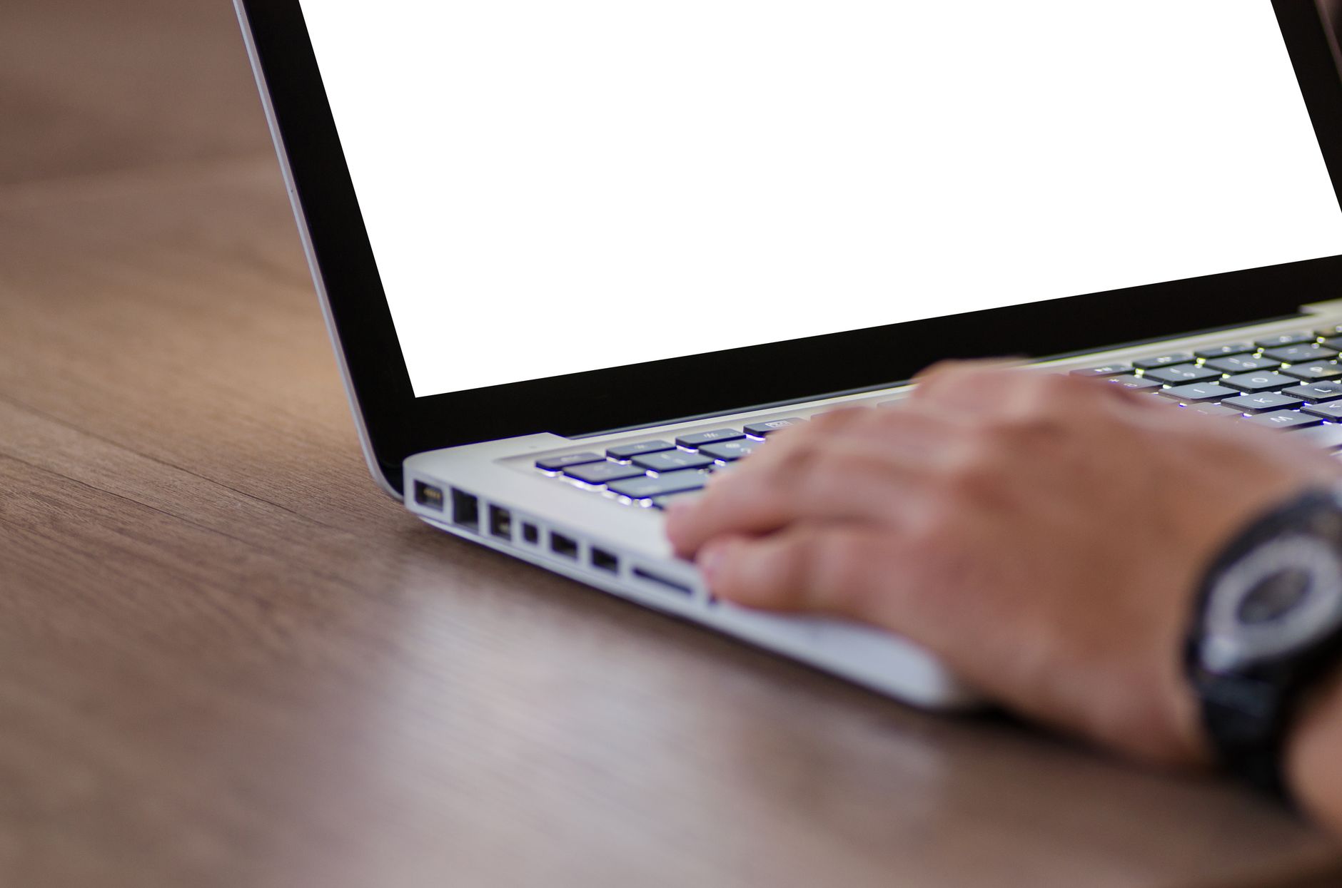 Main sur le clavier d'un ordinateur portable ouvert sur un écran blanc